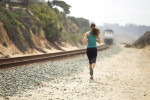 Female joggin next to railroad